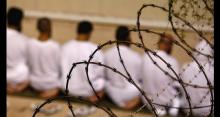 Photo of prisoners behind a barbed wire fence