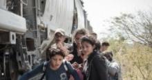 Child migrants from central america climb on a train heading north