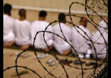 Photo of prisoners behind a barbed wire fence