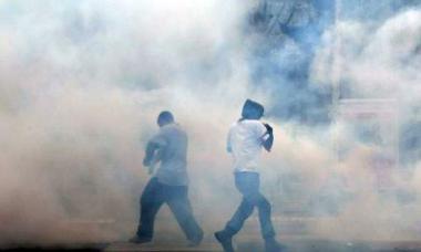 Photo: two people being engulfed by tear gas.