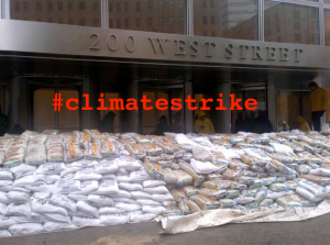 Meme of Goldman Sachs Tower behind sandbags, accompanying the article "Climate Strike: All Storms Lead to Wall Street." (Occupy Theory)